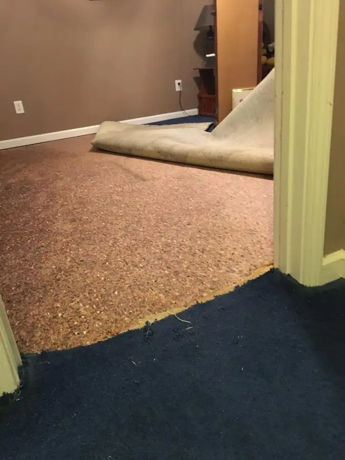 Carpet pad removal revealing water damage during Water Mitigation Services in North Fair Oaks